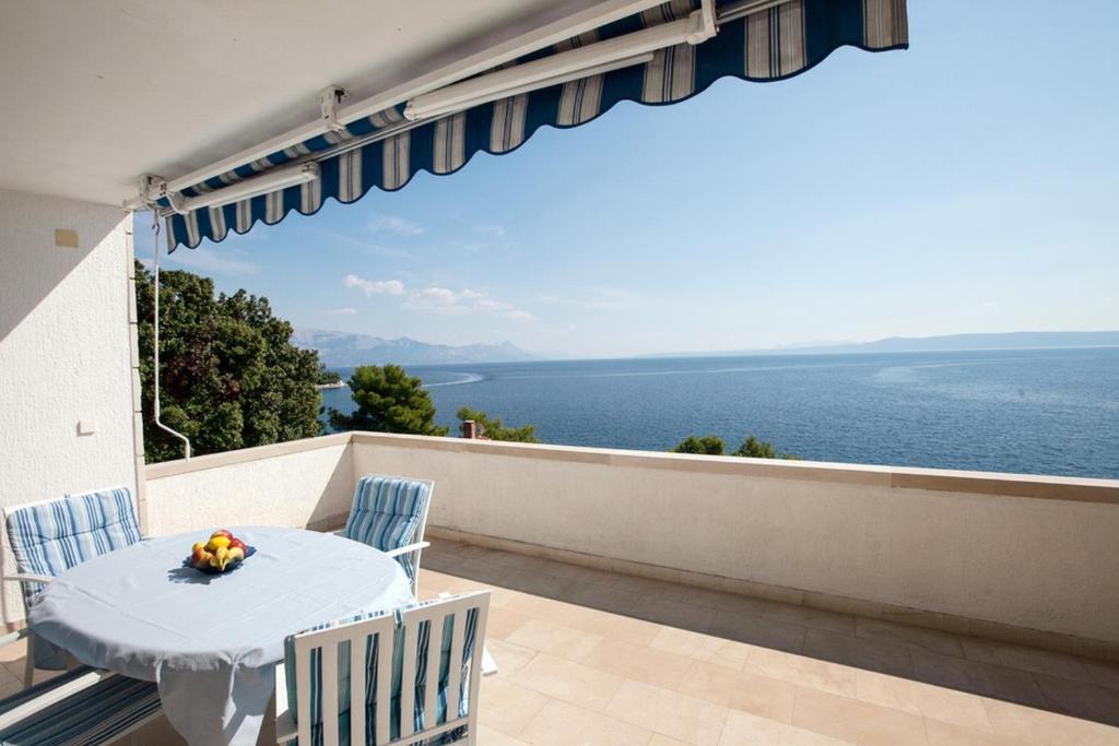 un tavolo e sedie su un balcone con vista sull'oceano di Villa Sarah a Selca