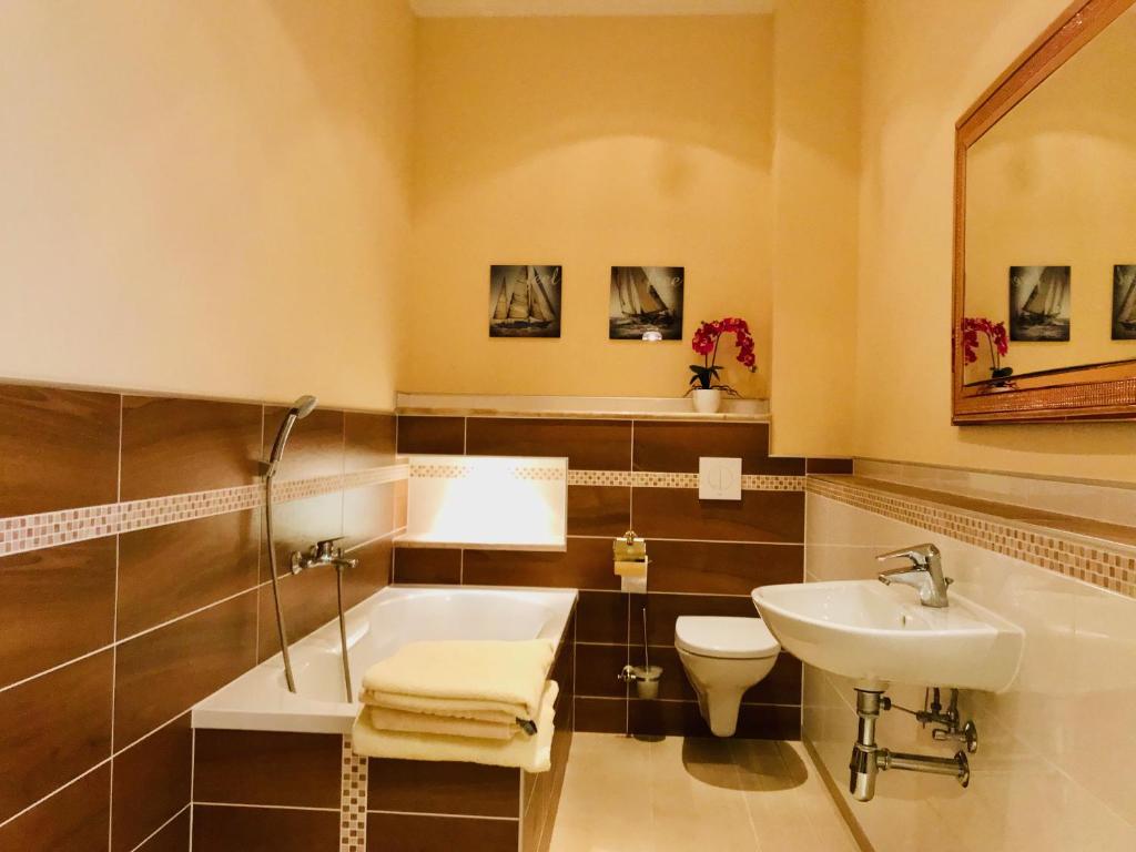 uma casa de banho com um lavatório, uma banheira e um WC. em Mediterrane Luxusferienwohnung 5, Berlin- Köpenick, Am Müggelsee em Berlim