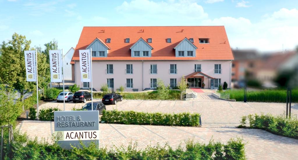 ein großes weißes Gebäude mit orangefarbenem Dach in der Unterkunft ACANTUS Hotel in Weisendorf