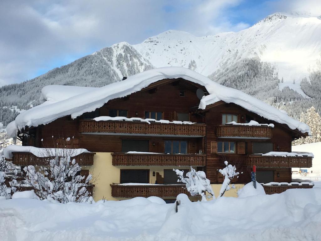 een gebouw bedekt met sneeuw met bergen op de achtergrond bij Haus am Golfplatz in Selfranga