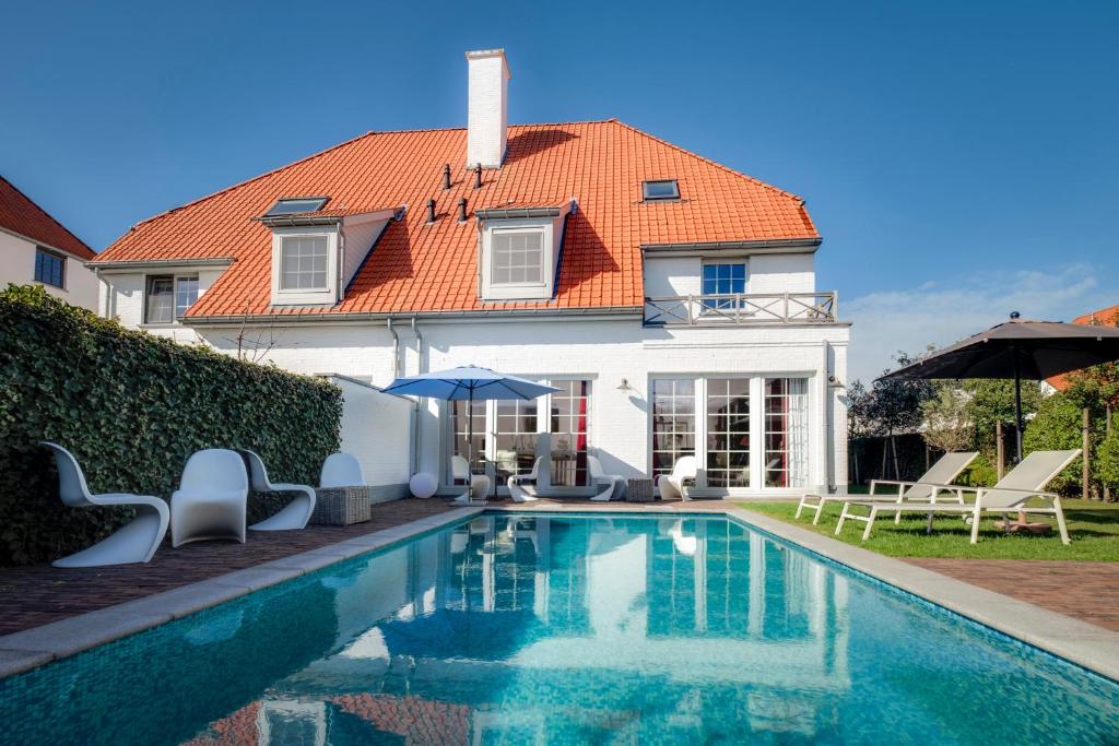 a house with a swimming pool in front of a house at B&B Maison seki in Knokke-Heist