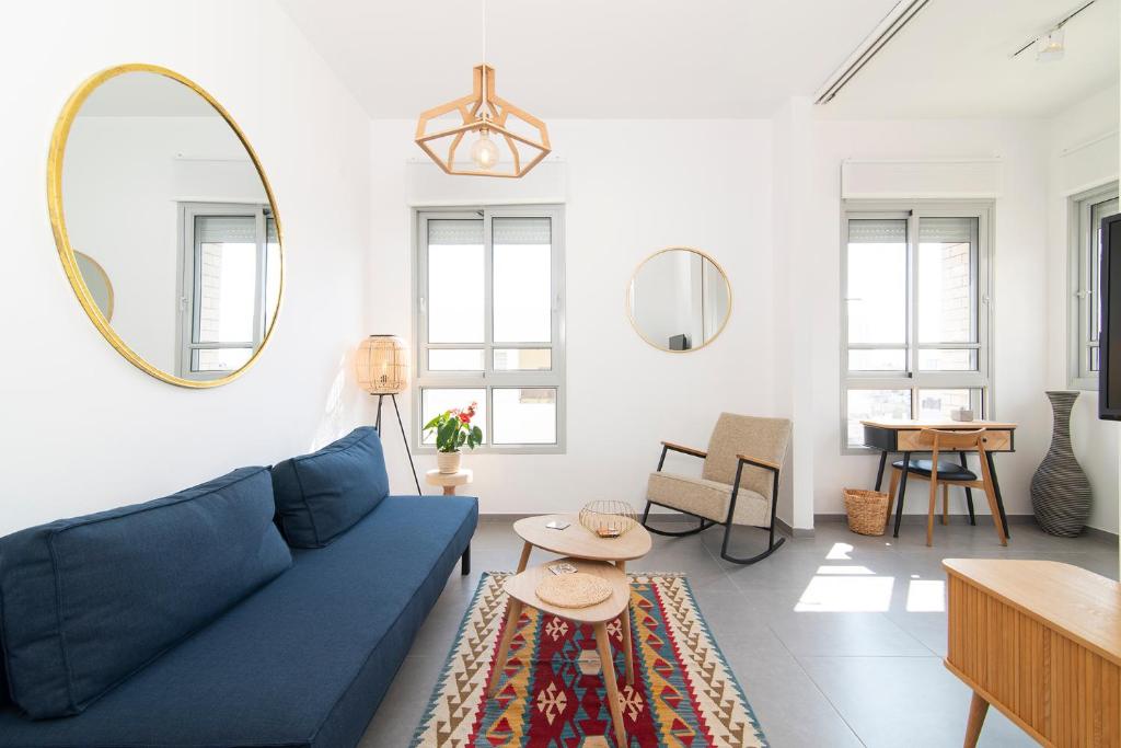 a living room with a blue couch and a table at Allenby 36 Bauhaus Residence 5 Stars in Tel Aviv