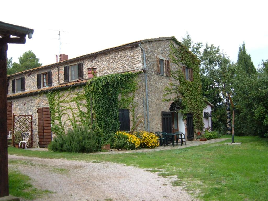 Una casa de piedra con hiedra a un lado. en Pian del Noce en Magliano in Toscana