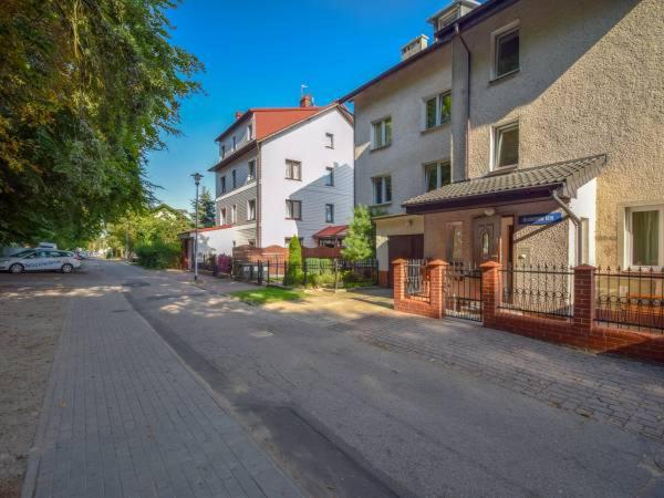 an empty city street with buildings and a fence at Pokoje Klonowa in Kołobrzeg
