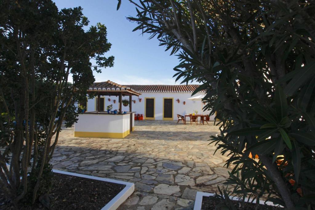 a courtyard of a house with a table and chairs at Monte do Papa Leguas in Zambujeira do Mar