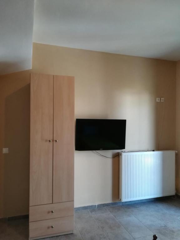 a room with a flat screen tv and a cabinet at Serifos Palace in Livadakia