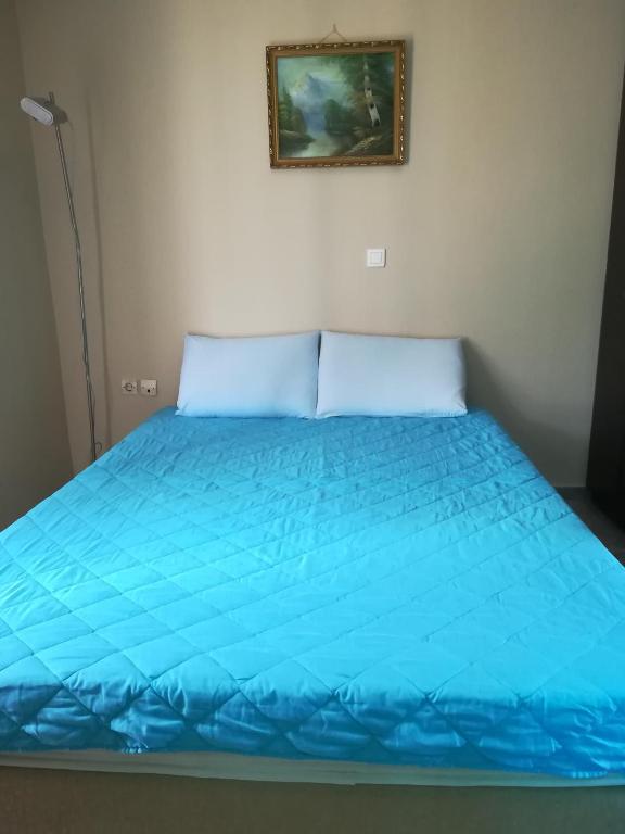 a bed with a blue comforter in a room at Serifos Palace in Livadakia