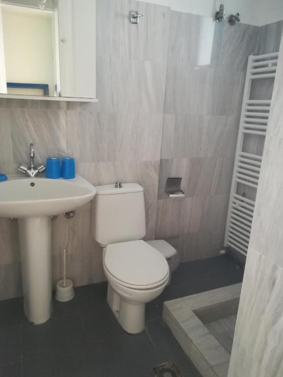 a bathroom with a white toilet and a sink at Serifos Palace in Livadakia