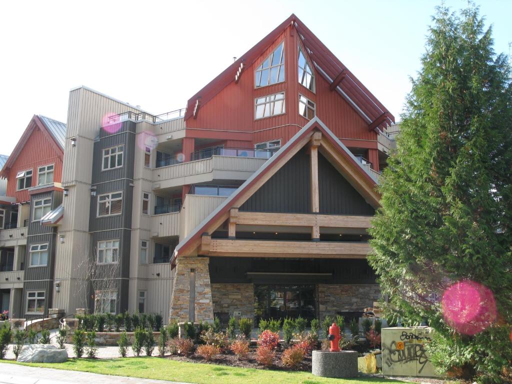 duży budynek apartamentowy z czerwonym dachem w obiekcie Lake Placid Lodge by Whistler Retreats w mieście Whistler