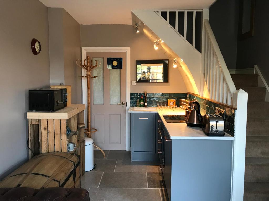 a kitchen with a counter and a staircase at Fistral Court in Newquay