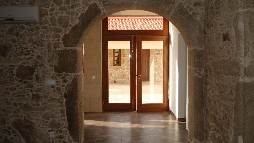 un corridoio con porta in legno su un muro di pietra di Casa da Trapa a Oliveira de Azeméis