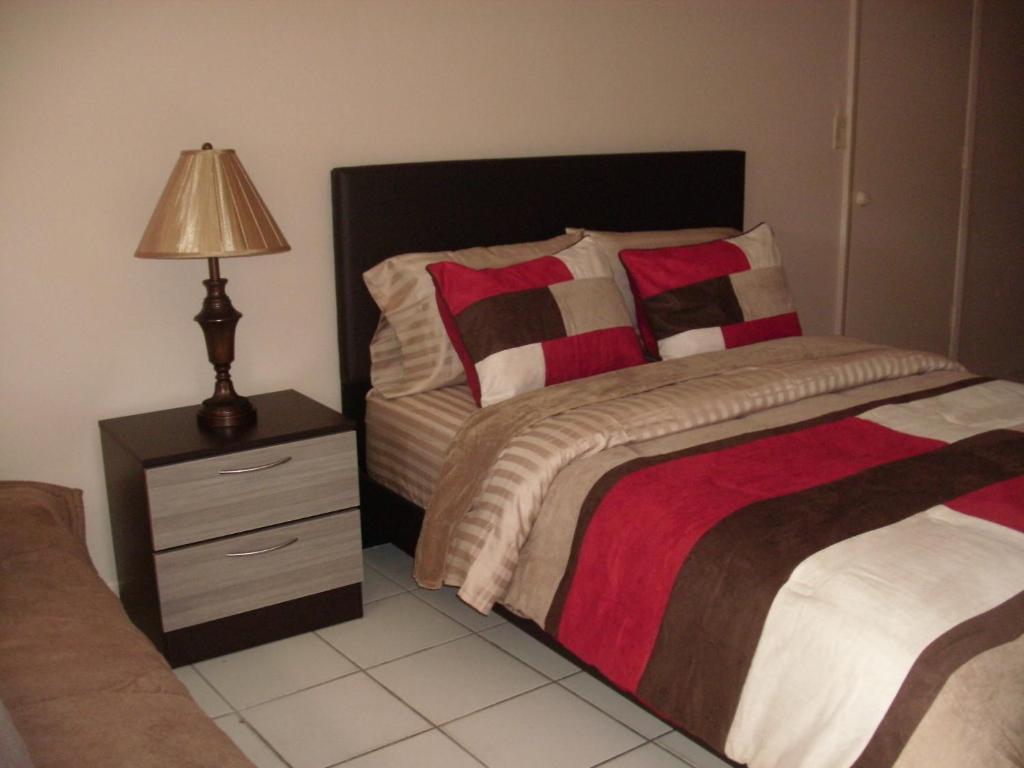 um quarto com uma cama e uma mesa de cabeceira com um candeeiro em Newly Furnished Large, Clean, Quiet Private Unit em Fort Lauderdale