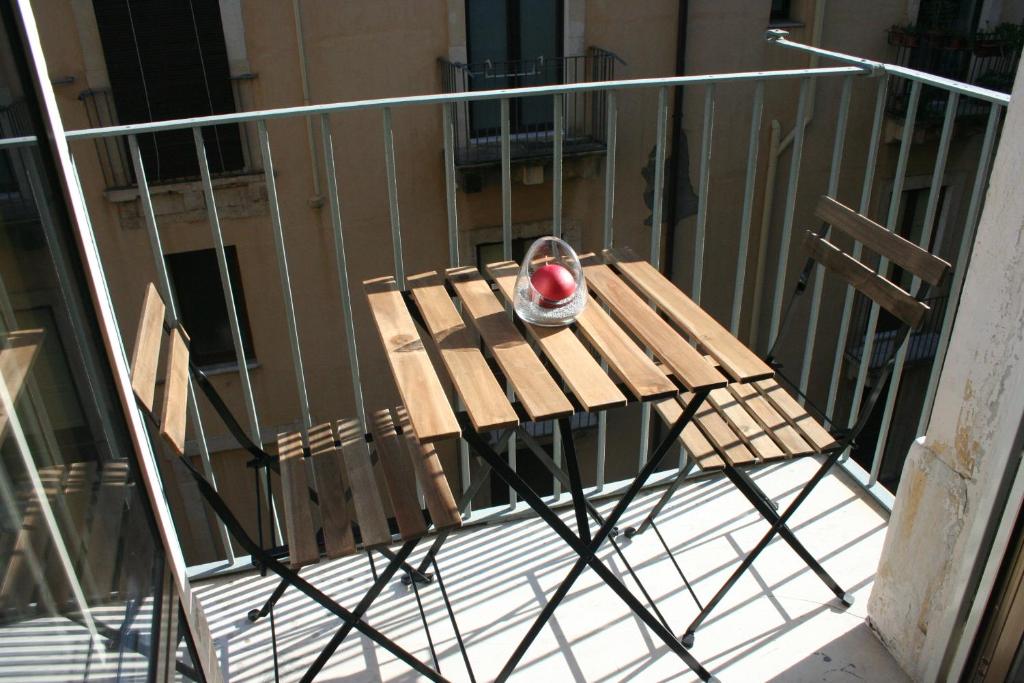 a table with an apple on it on a balcony at Katane Apartment in Catania