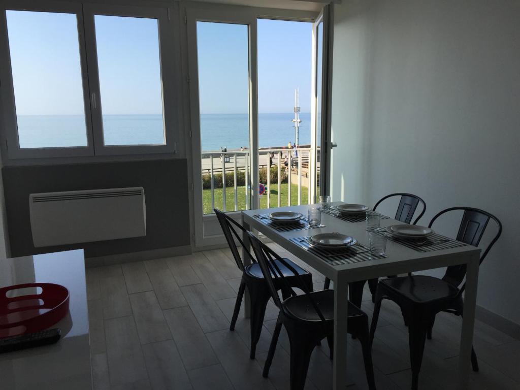 - une salle à manger avec une table et des chaises offrant une vue sur l'océan dans l'établissement Entre mer et falaises, au Tréport