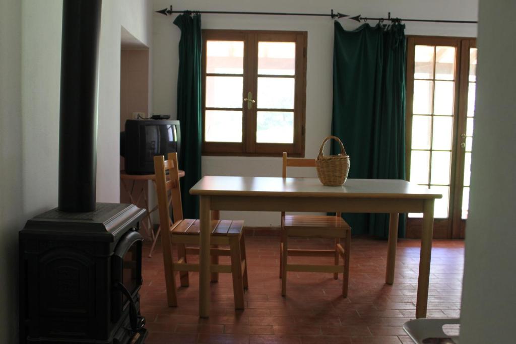 salon ze stołem, krzesłami i kuchenką w obiekcie Pian del Noce w mieście Magliano in Toscana