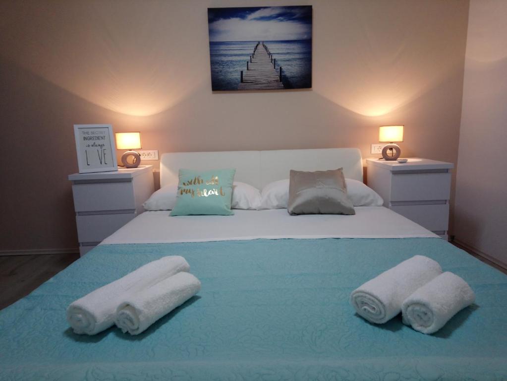 een slaapkamer met een bed met handdoeken erop bij Aquamarine apartment in Split