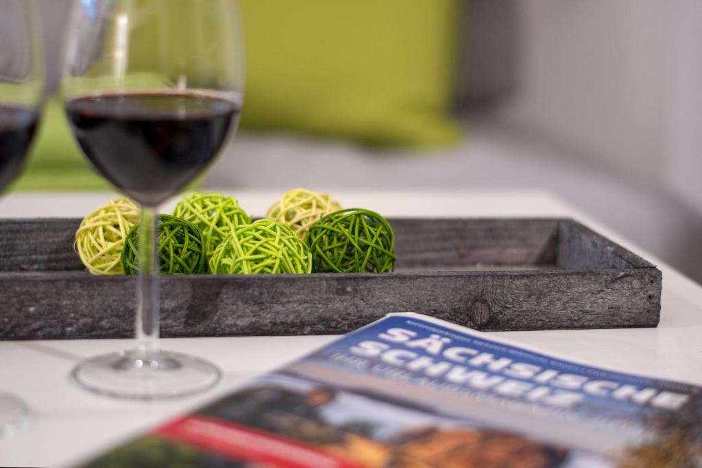 a glass of wine sitting next to a tray of pasta at Apartmenthaus Luise in Bad Schandau