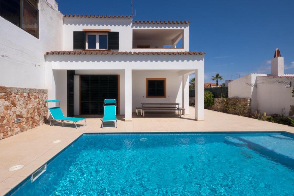 a villa with a swimming pool in front of a house at Llevant 11 E1 in Cala en Bosc