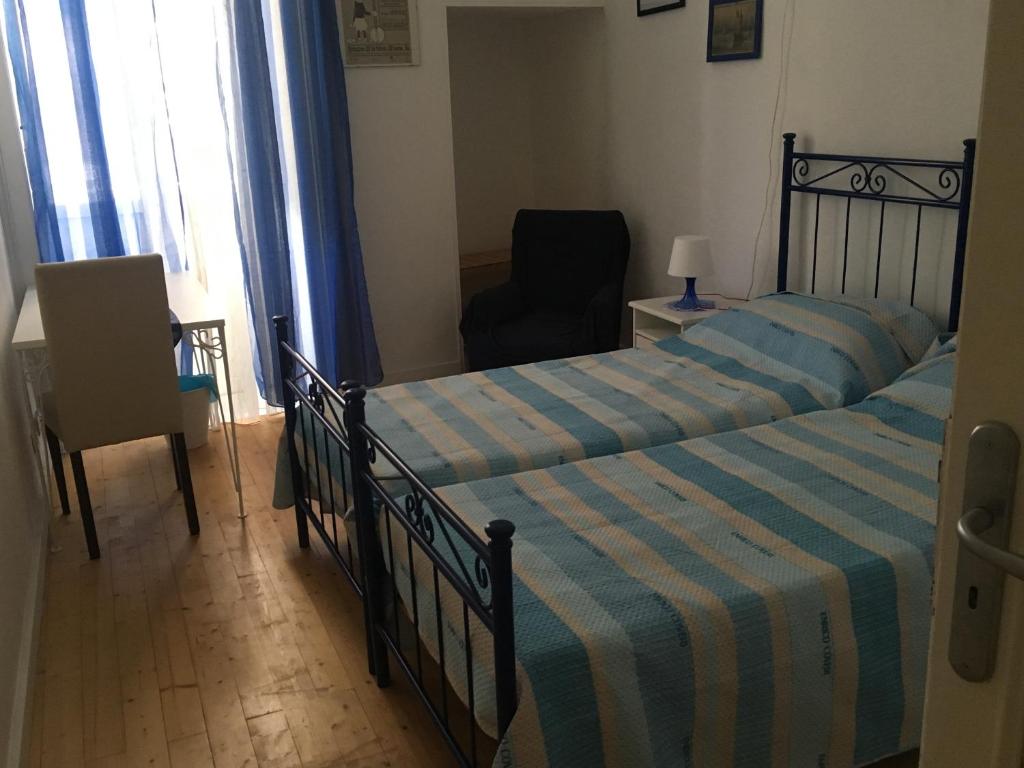 ein Schlafzimmer mit 2 Betten und einem Stuhl in einem Zimmer in der Unterkunft B&B Domus Gaetani in Syrakus