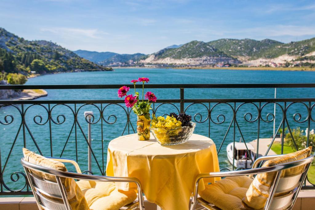 a table with a yellow table cloth and flowers on a balcony at House Ljilja in Rogotin
