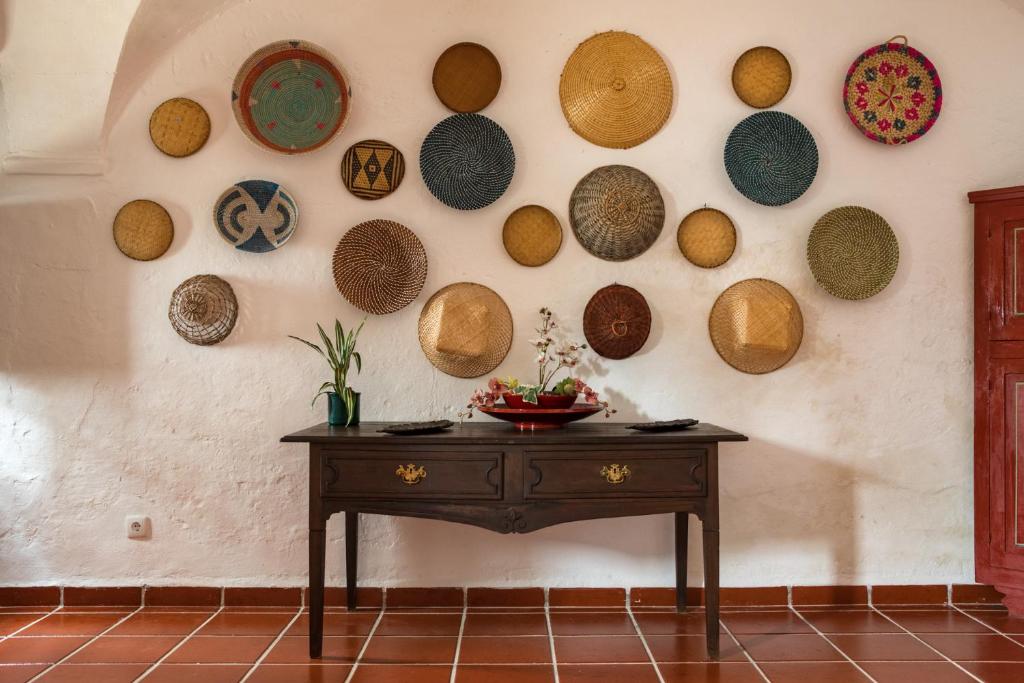 ボルバにあるCasa da Frenteのテーブルと皿が壁に掛けられた部屋