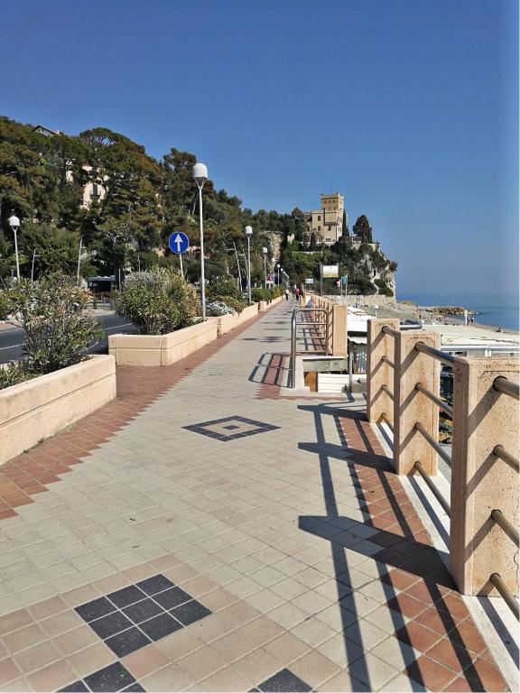 un marciapiede accanto all'oceano con una recinzione di Casa Vincenzina a Finale Ligure