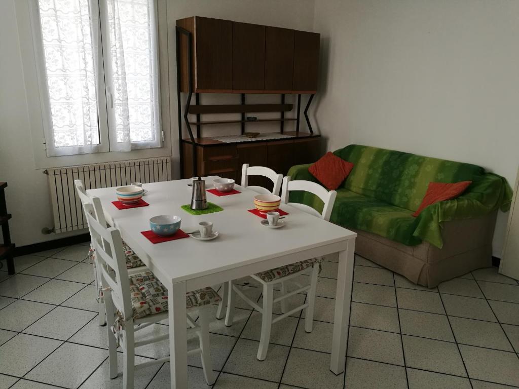 un tavolo bianco e sedie in soggiorno con divano di Casa Vincenzina a Finale Ligure