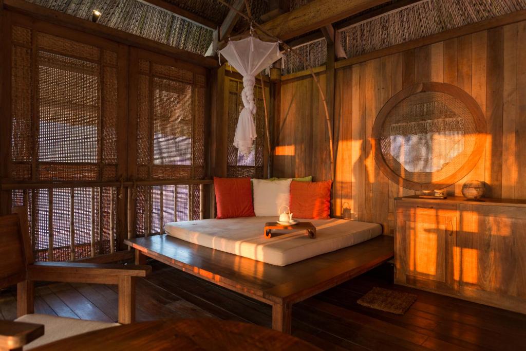 a bedroom with a bed in a room with wooden walls at Six Senses Ninh Van Bay in Ninh Van Bay