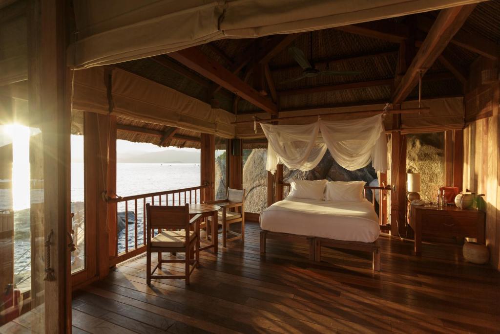 a bedroom with a bed and a balcony at Six Senses Ninh Van Bay in Ninh Van Bay