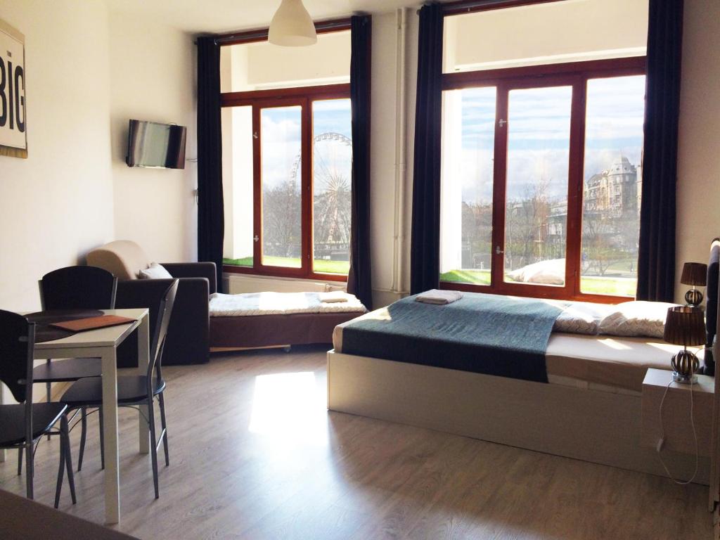 ブダペストにあるZoom-Budapest Apartmentsのベッドルーム1室(ベッド1台、テーブル、椅子付)