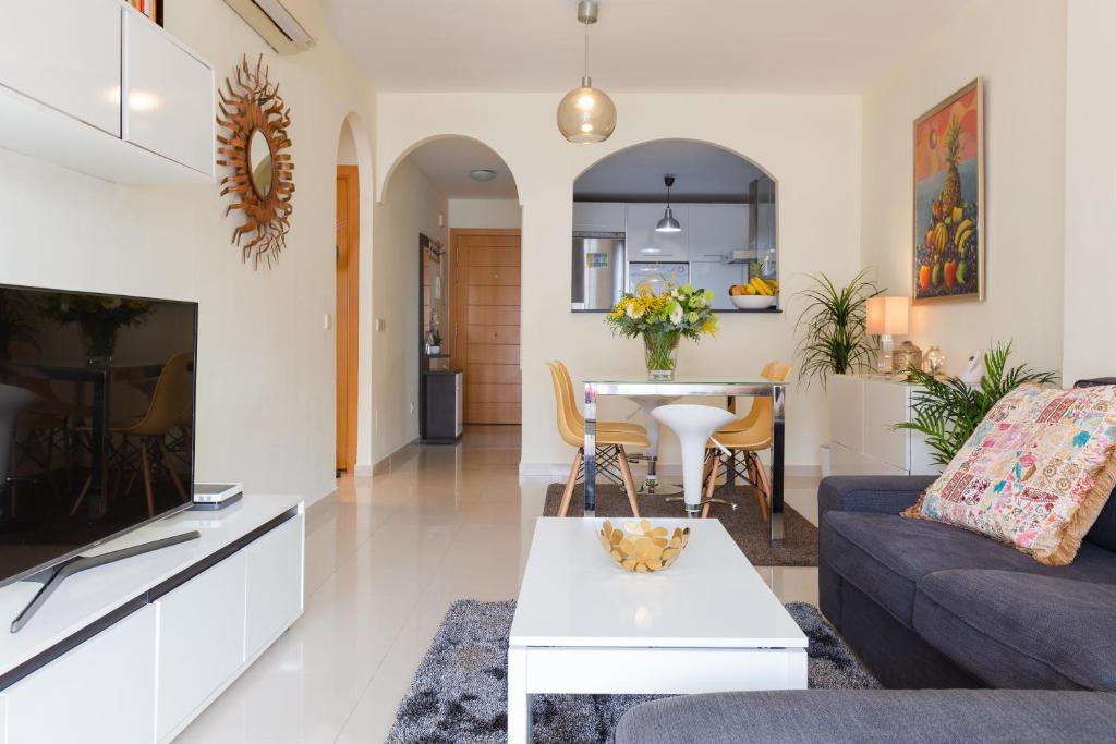 ein Wohnzimmer mit Sofa und Tisch in der Unterkunft Precioso Apartamento la Marina in Rincón de la Victoria