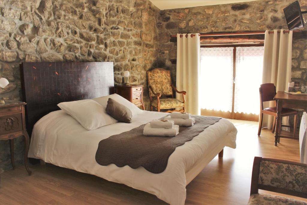 a bedroom with a large bed with towels on it at L'Auberge De Montpezat in Montpezat-sous-Bauzon