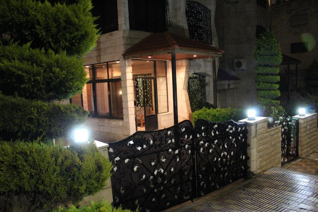 une maison avec une clôture en fer forgé la nuit dans l'établissement Dhahiyat Al-Rasheed, à Amman
