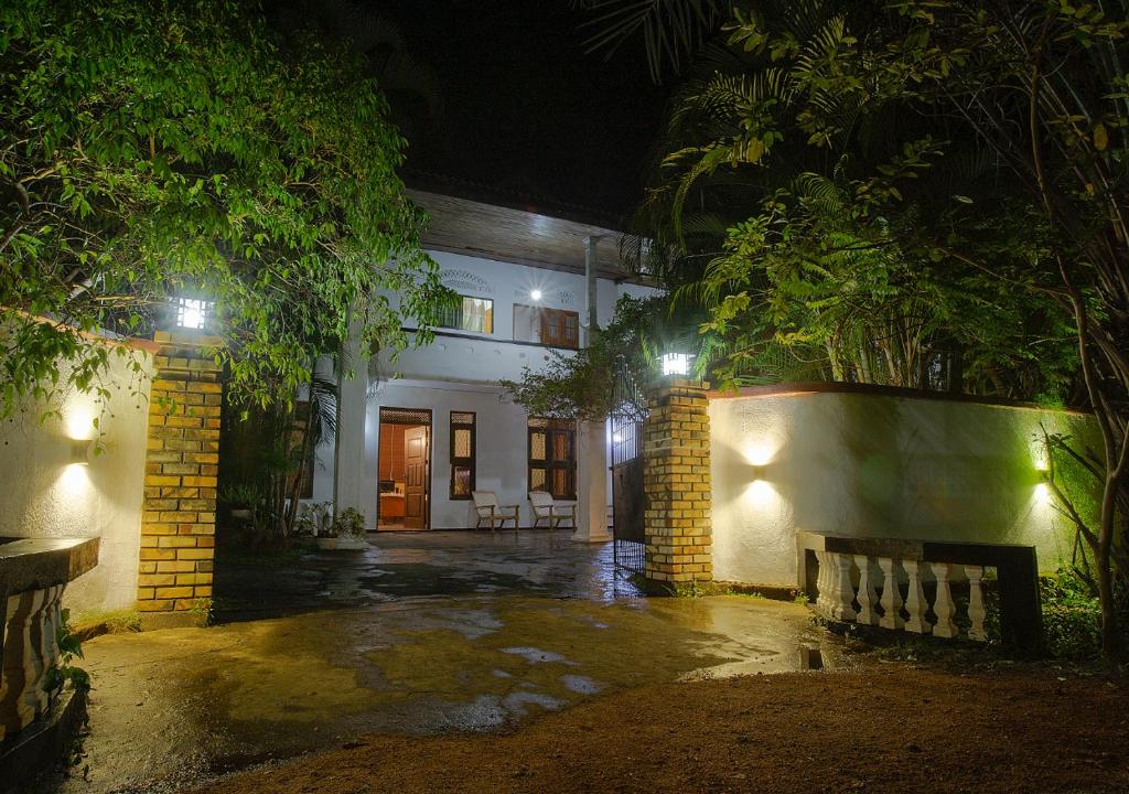 a building with a bench in front of it at night at Aura City Hostel in Anuradhapura