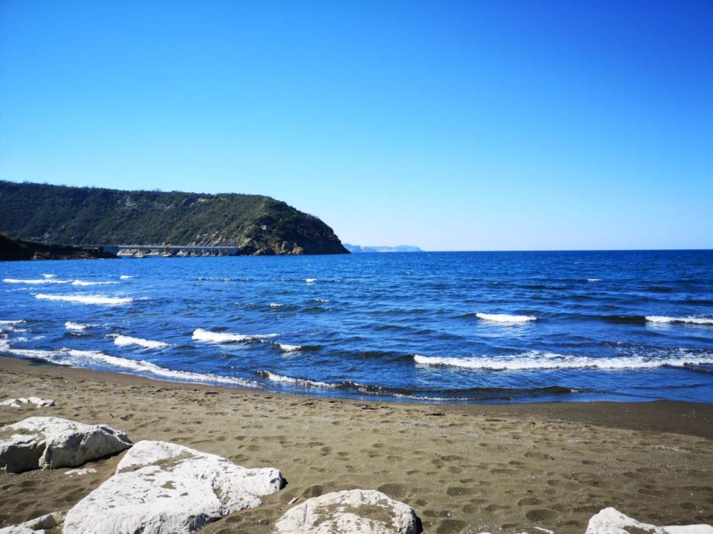 a beach with some rocks and the ocean at Lido Di Procida Guest House in Procida