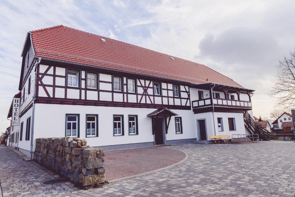 ein großes weißes Gebäude mit rotem Dach in der Unterkunft Landgasthof Schwabhausen in Schwabhausen