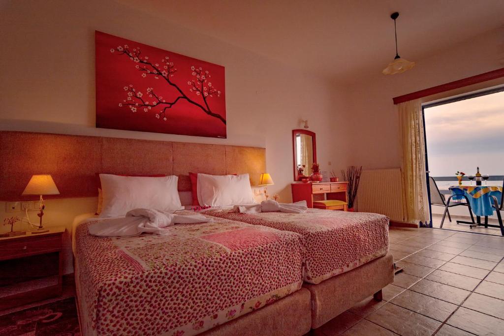 パレオコラにあるRoula Apartmentsのベッドルーム1室(赤い絵画の壁にベッド1台付)