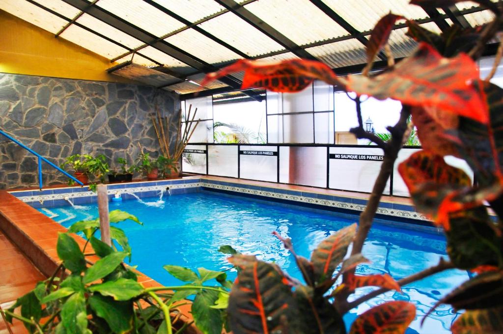 a large swimming pool in a building with plants at Departamentos KA.RI.VE in Termas de Río Hondo