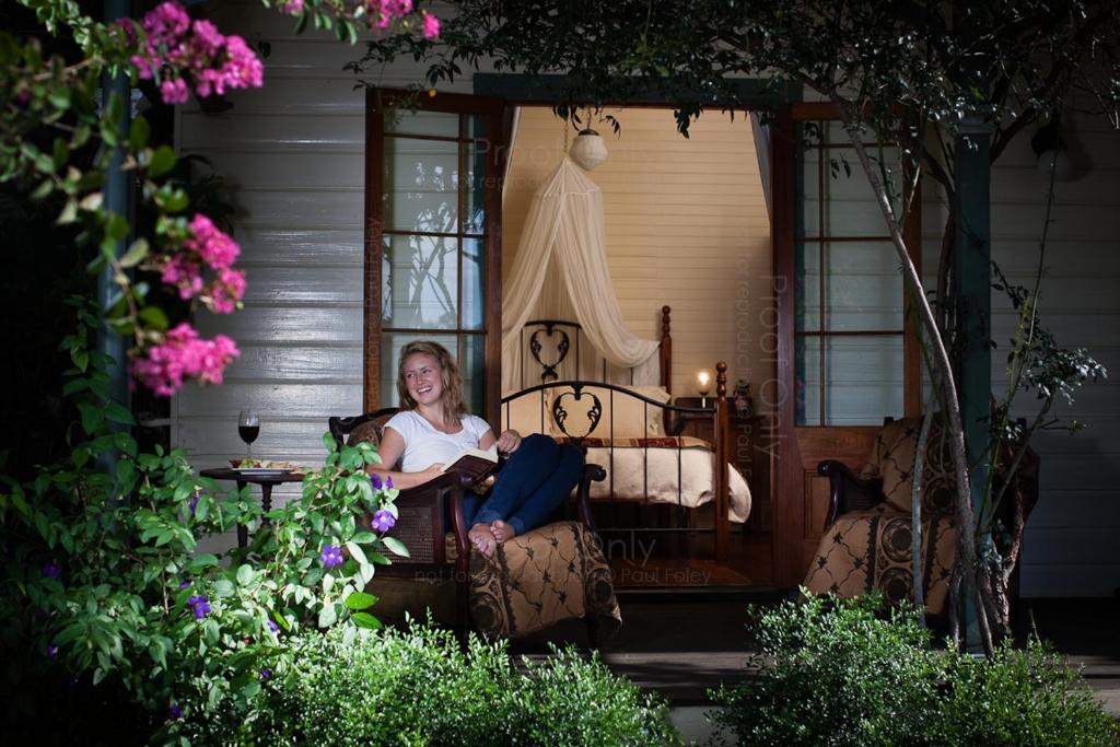 une femme assise sur une chaise sur une terrasse couverte dans l'établissement Maddies of Bolwarra, à Maitland