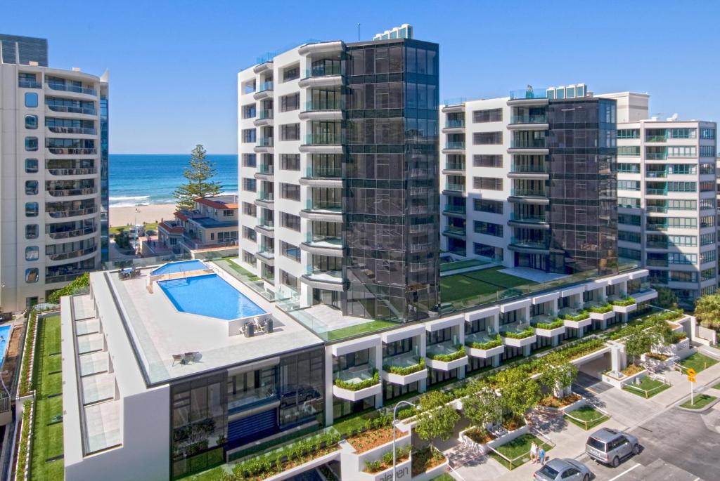 an aerial view of a building with a pool and the ocean at Ocean Eleven 3 in Mount Maunganui
