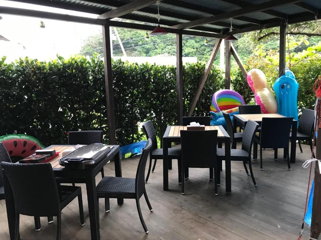 eine Gruppe von Tischen und Stühlen auf einer Terrasse in der Unterkunft Yenn's Marina Inn Zamami Condominium in Zamami