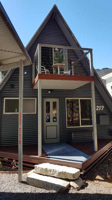 a black house with a porch and a balcony at The A-Frame in Halls Gap