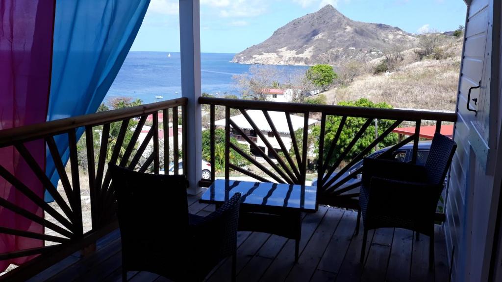 a balcony with a table and chairs and a view of the ocean at bel ti kay in Les Anses-dʼArlets