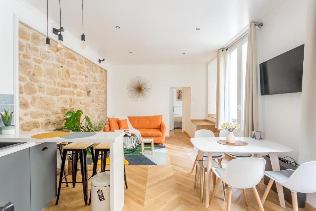 Il comprend une cuisine et un salon avec un mur en pierre. dans l'établissement Amazing Apartment Notre Dame Boulevard St-Germain - 4 Bedrooms, à Paris