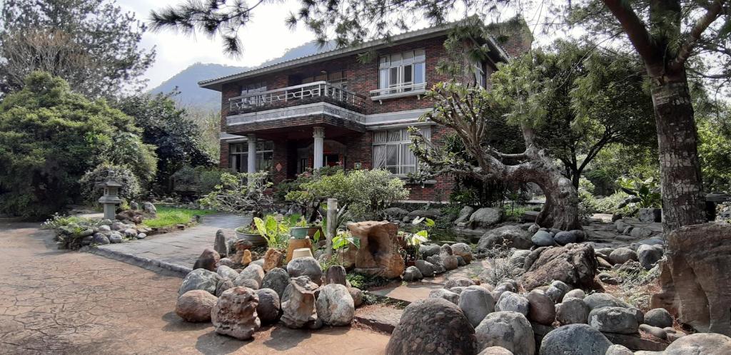 een huis met een bos stenen ervoor bij Ri Jing Yuan Homestay in Liugui