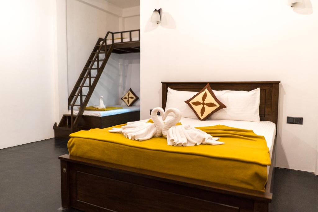 duas toalhas de cisne numa cama num quarto em Green Leaf Resort em Ella