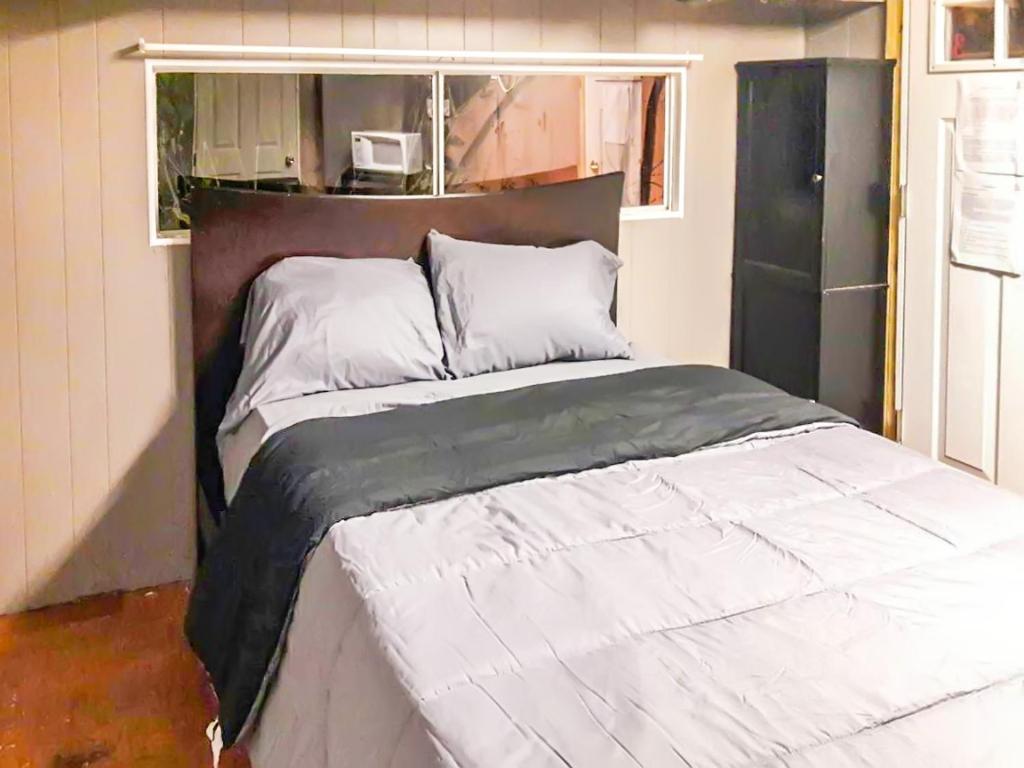 a bedroom with a large bed with white sheets at Co-ed Dorm with Fantastic Patio! in Ewing