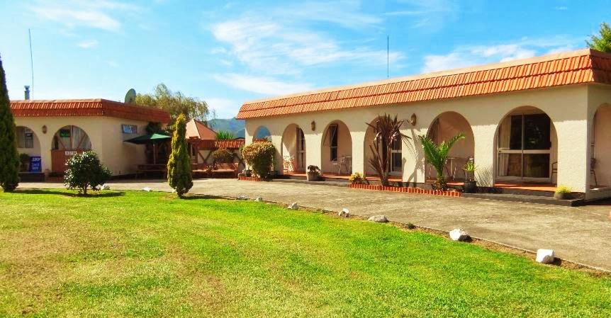 a house with a green lawn in front of it at Casa Mexicana in Paeroa