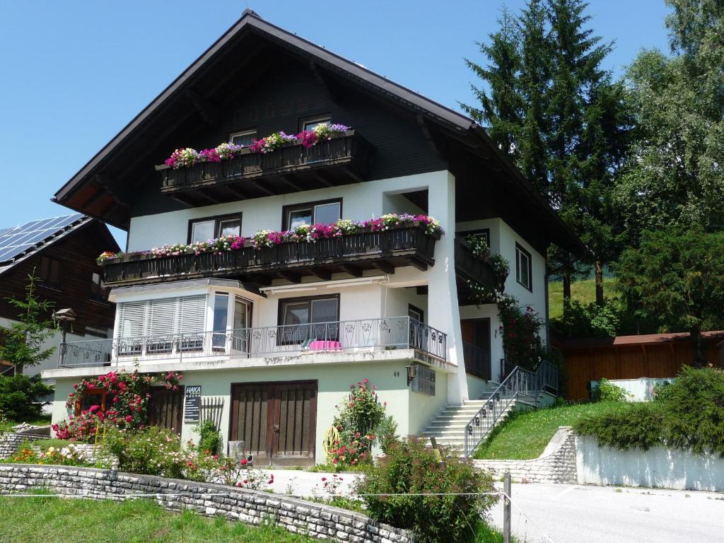ein weißes Haus mit Blumen auf dem Balkon in der Unterkunft Gästehaus Kühnle in Pichl bei Aussee