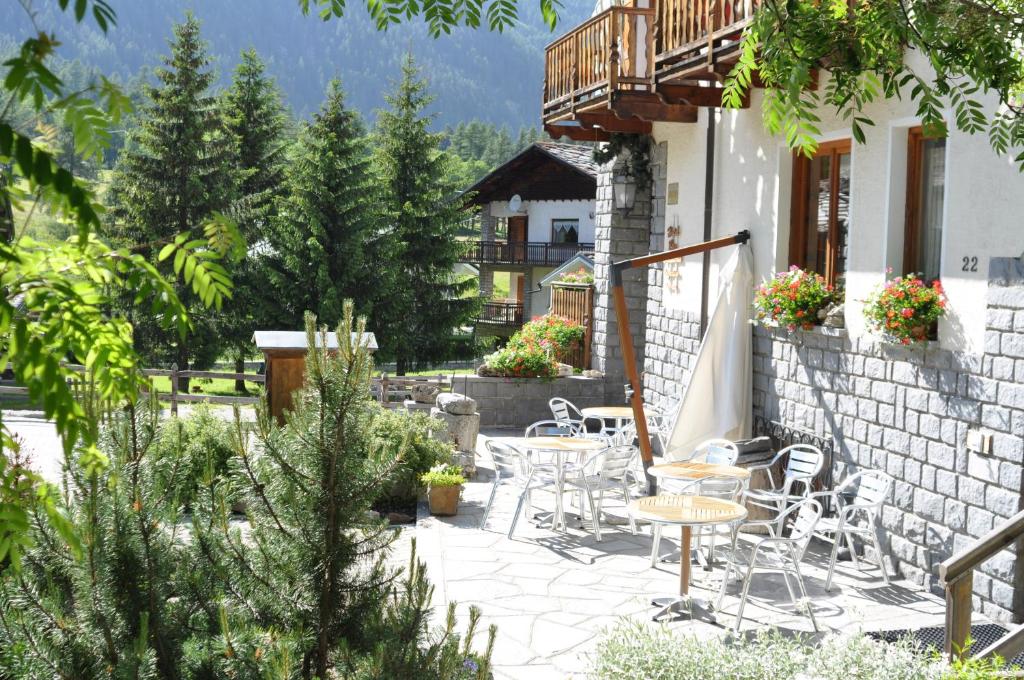 a patio with tables and chairs on a building at Hotel Flora Alpina in Gressoney-Saint-Jean
